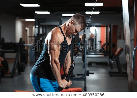 Stockfoto: Young Man Exercising Triceps In The Gym