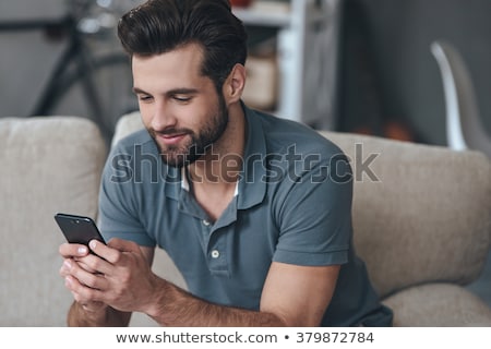 Stockfoto: Man Texting On His Couch