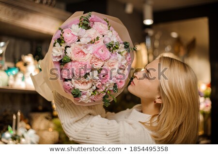 Foto d'archivio: Elegant Young Blonde Holding A Beautiful Pink Rose