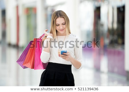 Stockfoto: Woman Look At Mobile Phone With Paperbags In The Mall While Enjo