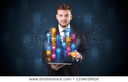 Stock photo: Man Holding Tablet With Hologram App Icons Above