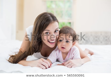 Сток-фото: Happy Mother With Baby Lying On Bed At Home