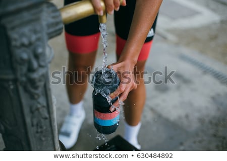 Stock photo: Man Filling A Bottle With Water From A Fountain