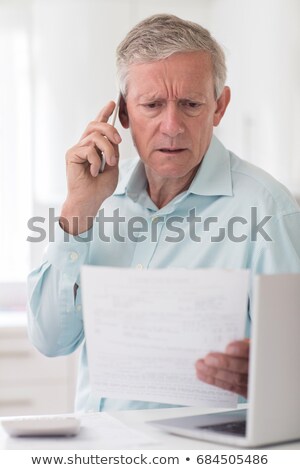 Foto d'archivio: Unhappy Senior Man On Phone Querying Bill