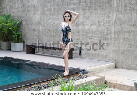 Stockfoto: Beautiful Young Woman Standing In A Swimming Pool