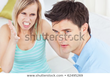 Stok fotoğraf: Young Man Ignoring His Girlfriend Getting Worked Up Both Sitting In The Living Room