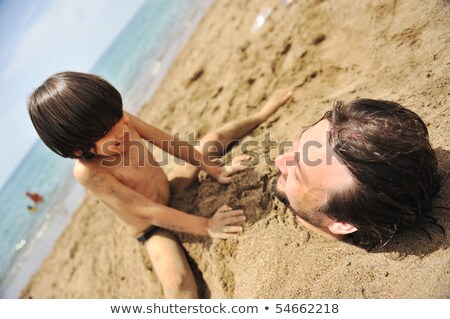 Felicidade real brincando na praia, meu pai, debaixo da areia Foto stock © Zurijeta