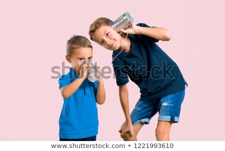 Stock photo: Young Friends Talking Through Tin Phone