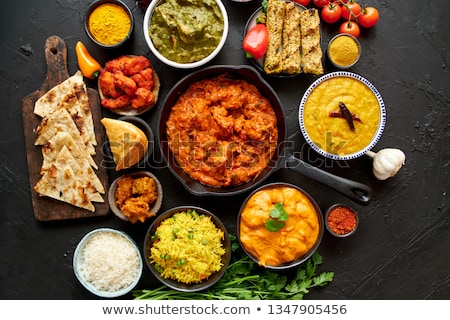 Foto stock: Various Indian Dishes On A Table Spicy Chicken Tikka Masala In Iron Pan