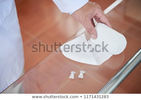 Stock photo: Crop Doctor Unrolling Bandage
