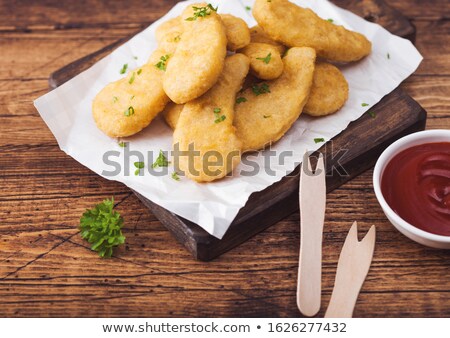 Stockfoto: Buttered Chicken Nuggets On Chopping Board With Wooden Forks And Ketchup On Wooden Background