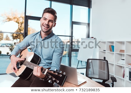 Stock photo: Young Handsome Businessman Playing Guitar In The Office