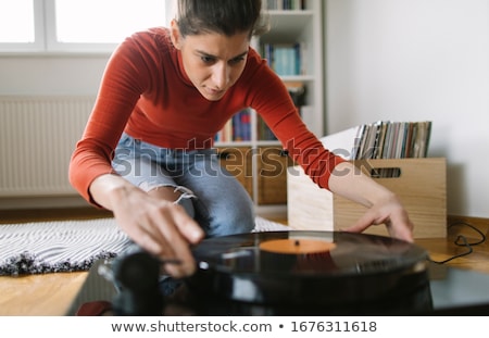 Stok fotoğraf: Young Woman Playing A Gramophone At Home