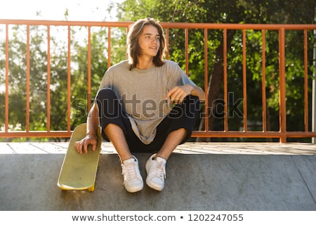 Foto stock: Photo Of Handsome Skater Guy 16 18 In Casual Wear Sitting On Ram