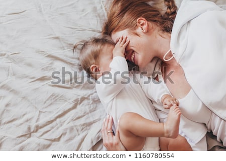 Foto stock: Top View Of Beautiful Young Mother And Her Daughter In Bed At Home