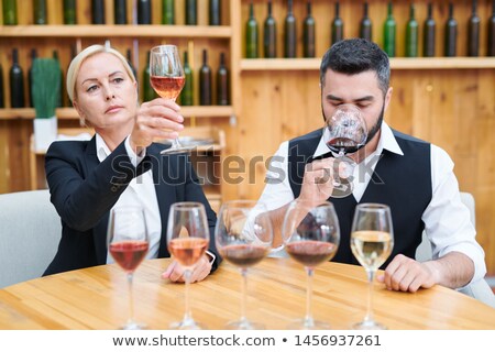 Foto d'archivio: Elegant Man And Woman Examining Color Taste And Smell Of New Sorts Of Wine
