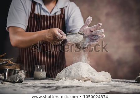 Stock photo: Close Up Of Man Hands Sprinkling Flour Over Fresh Dough With Ing