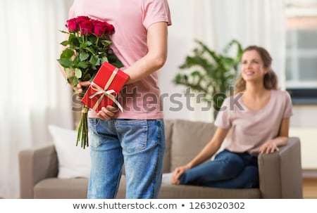 Stockfoto: Woman Looking At Man With Bunch Of Flowers At Home