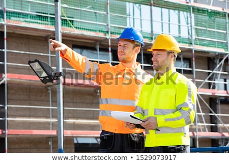 Stock fotó: Supervisor Looking At Architect Writing On Clipboard