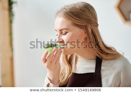 Foto d'archivio: Young Woman Enjoying Smell Of Fresh Conifer On Top Of Green Handmade Soap Bar