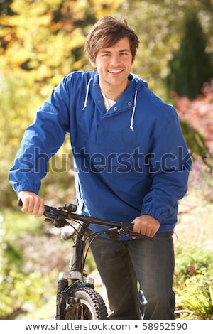 Zdjęcia stock: Portrait Of Young Man With Cycle In Autumn Park