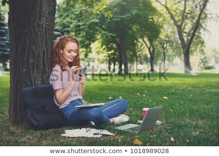 Zdjęcia stock: Pretty Pensive Womanlistening To Music Under The Tree