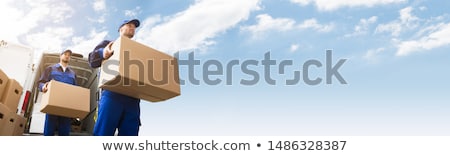 [[stock_photo]]: Male Courier With Two Cardboard Boxes