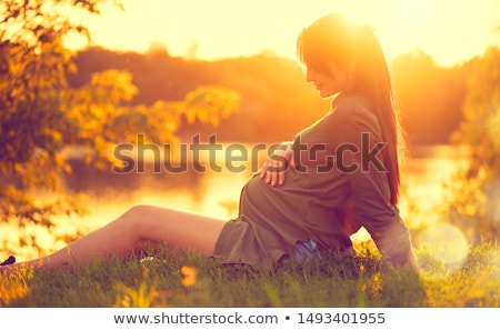 Foto stock: A Pregnant Girl At Sunset