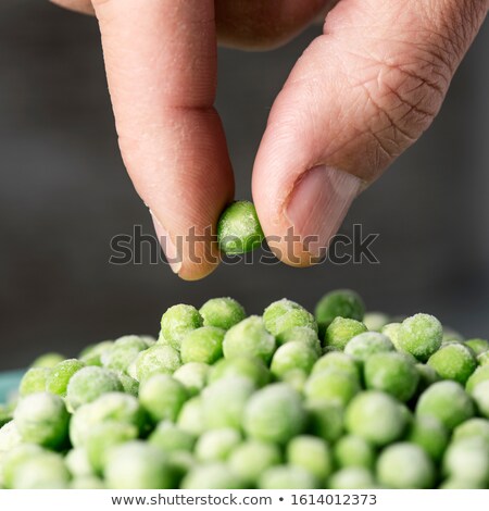 Stok fotoğraf: Man Picking A Frozen Green Pea