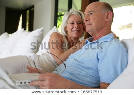 Stok fotoğraf: Couple Sat On Their Veranda With Laptop