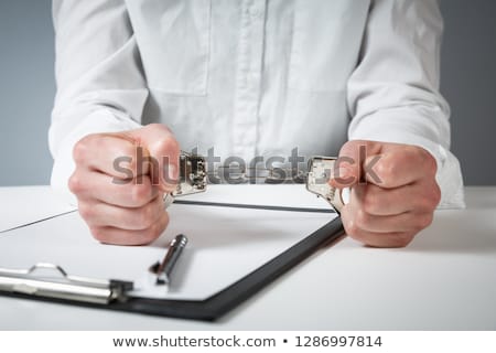 [[stock_photo]]: Female Hands Cuffed Signing Confession Top View