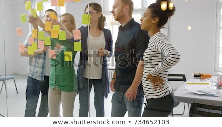 Foto stock: Creative Team With Scheme At Office Glass Board