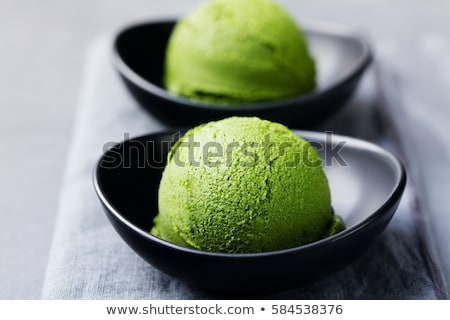 Foto d'archivio: Matcha Ice Cream Scoop In Bowl Stone Background