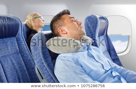 Foto stock: Man Sleeping In Plane With Cervical Neck Pillow