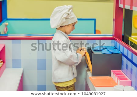 Foto stock: The Boy Plays The Game As If He Were A Cook Or A Baker In A Childrens Kitchen