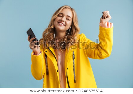 Foto stock: Image Of European Woman 20s Wearing Yellow Raincoat Holding Cell