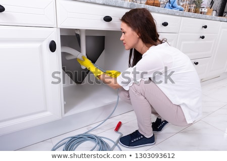 Foto stock: Woman Cleaning Clogged Sink Pipe