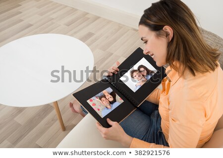 Stock fotó: Woman Looking At Photo Album