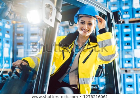 [[stock_photo]]: Woman Driving A Forklift In Logistics Delivery Center