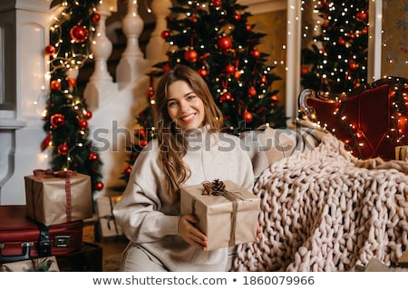 Foto d'archivio: Young Man Holding Gifts In Front Of Christmas Tree