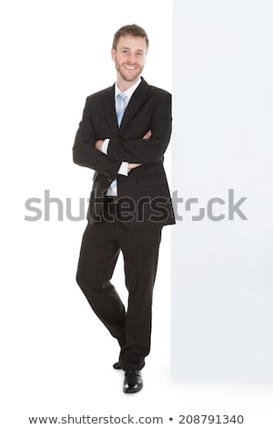 Stok fotoğraf: Businessman Leaning On A White Placard