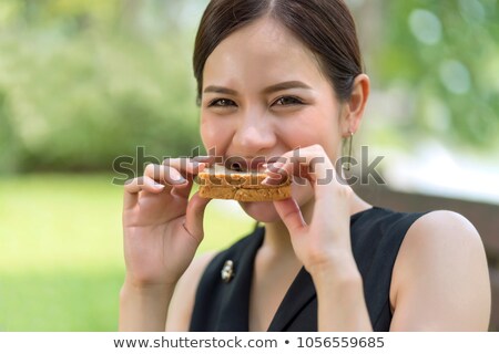 Сток-фото: Attractive Woman Sitting And Eating Bread With Chocolate Butter