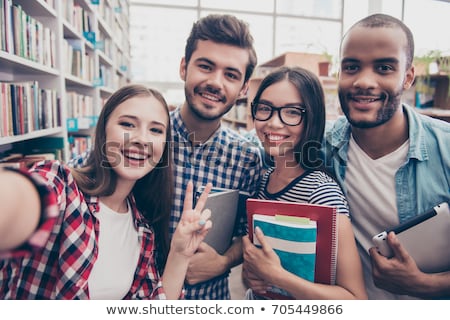 Foto d'archivio: Four Young Students In A Library