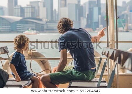 Foto stock: Father And Son Swim By Ferry Through Victoria Harbor In Hong Kongchina