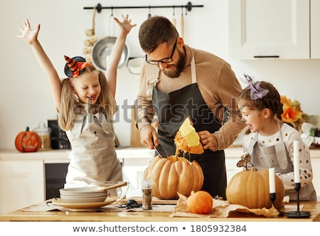 Stockfoto: Parents And Daughter In The Kitchen Preparing Pumpkin