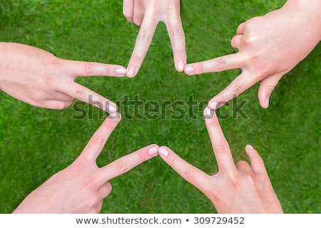 Сток-фото: Arms Of Girls With Hands Making Star Shape Above Grass