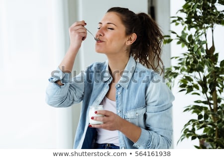 Stockfoto: Smiling Woman Eating Yogurt