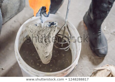 Stock fotó: Man Making Cement With A Construction Mixer In A Bucket