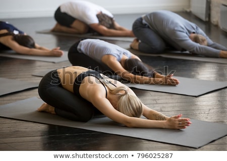 Stockfoto: Instructor With Student Practicing Child Pose In Health Club