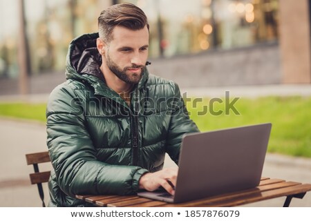 Zdjęcia stock: Confident Man Dressed In Coat Sitting At The Street